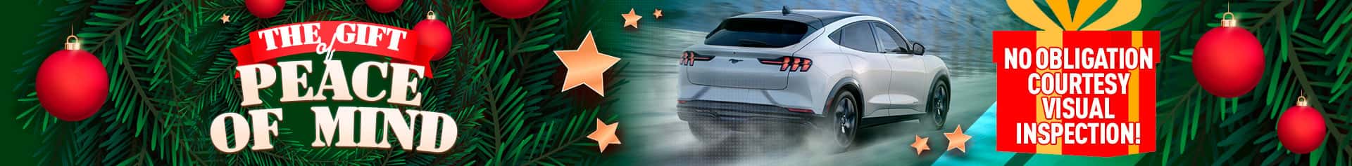 A winter holiday-themed graphic featuring a white Ford Mustang Mach-E driving on a snowy road. Festive ornaments, stars, and greenery surround the scene. A wreath displays the text “The Gift of Peace of Mind,” and a bright gift box promotes a “No obligation courtesy visual inspection.”
