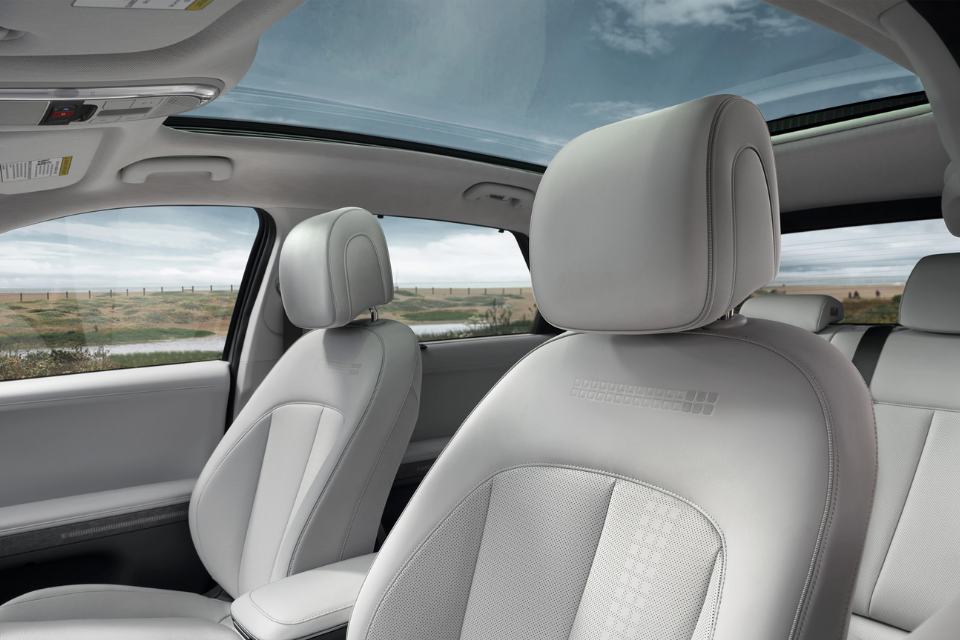 Front seats and panoramic glass roof of the 2026 Hyundai IONIQ 5, emphasizing its spacious and light-filled cabin