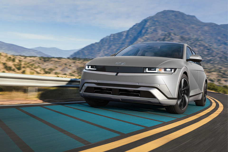 2026 Hyundai IONIQ 5 taking a corner on a mountain road, showcasing its agility and aerodynamic shape