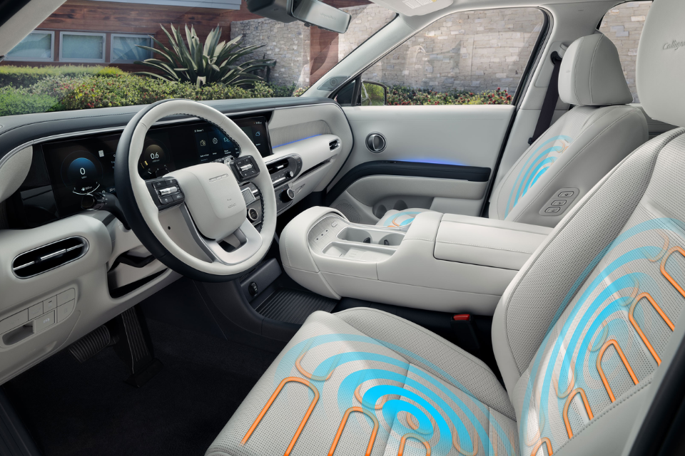 Front interior view of a Hyundai Palisade featuring light-coloured seats and dashboard with illuminated seat comfort graphics