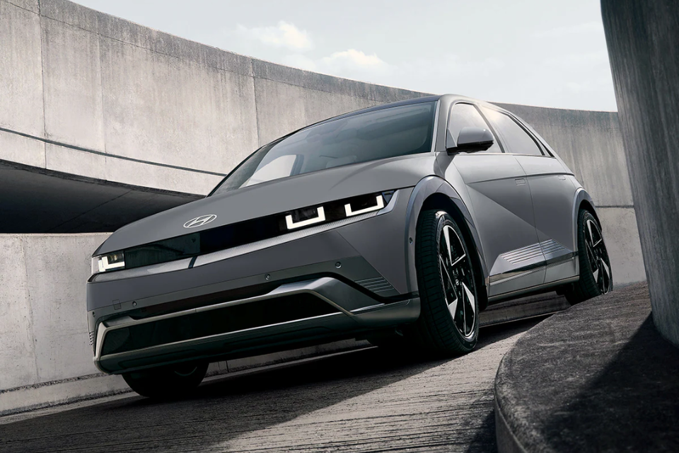 2026 Hyundai IONIQ 5 driving down a modern concrete ramp, showcasing its bold geometric styling
