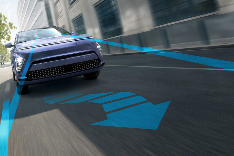 Hyundai Kona Electric driving with driver-assist visualization overlay, illustrating lane guidance and safety technology.