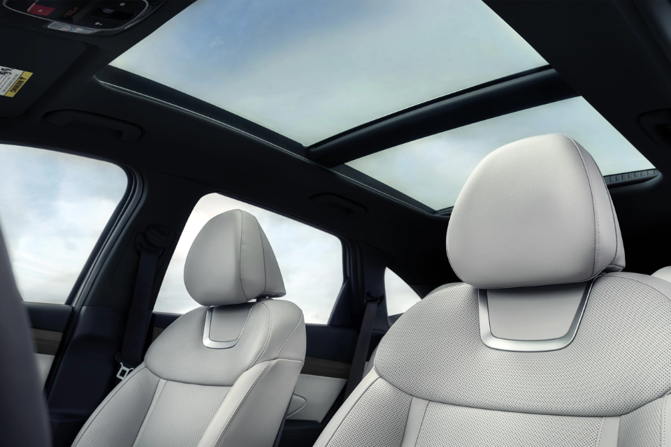 Interior front seats of the 2026 Hyundai Tucson Hybrid with panoramic sunroof and premium light upholstery.