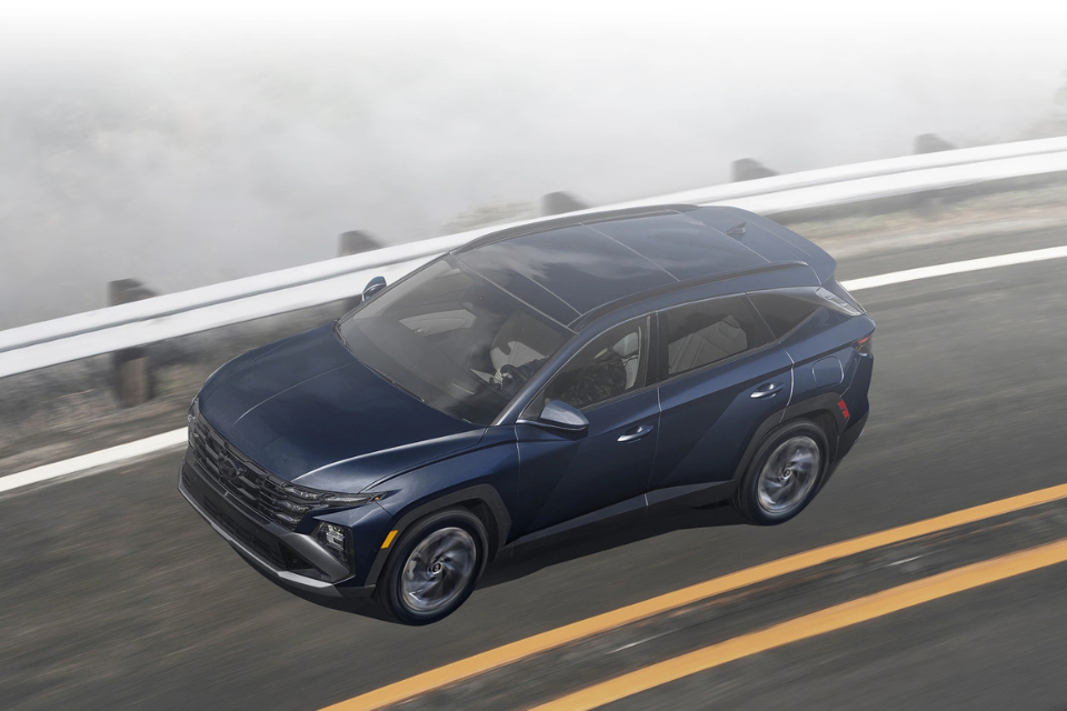 Aerial three-quarter view of the 2026 Hyundai Tucson Hybrid showcasing its bold body lines and panoramic roof.