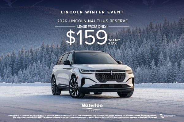 A silver 2026 Lincoln Nautilus Reserve SUV parked on a snowy road with a backdrop of snow-covered trees and soft winter lighting.