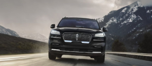 Lincoln Aviator driving on a wet mountain road in winter, demonstrating winter protection that Edmonton Lincoln owners rely on for safety and performance.