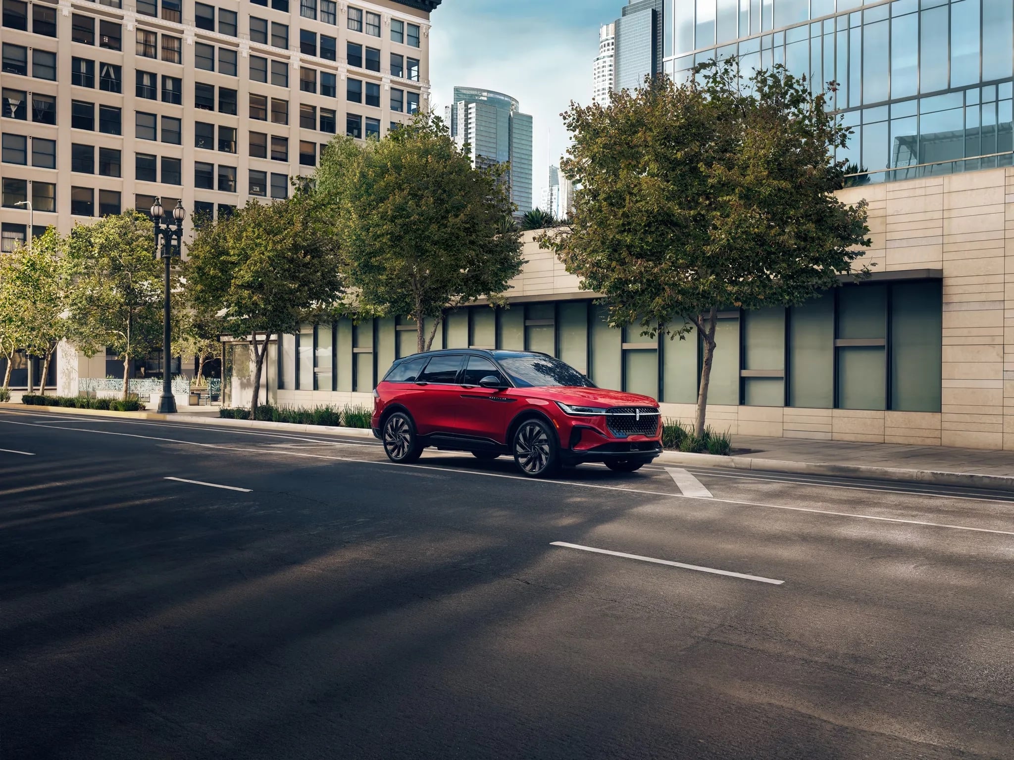 2026 Lincoln Nautilus red luxury SUV driving through modern downtown city street