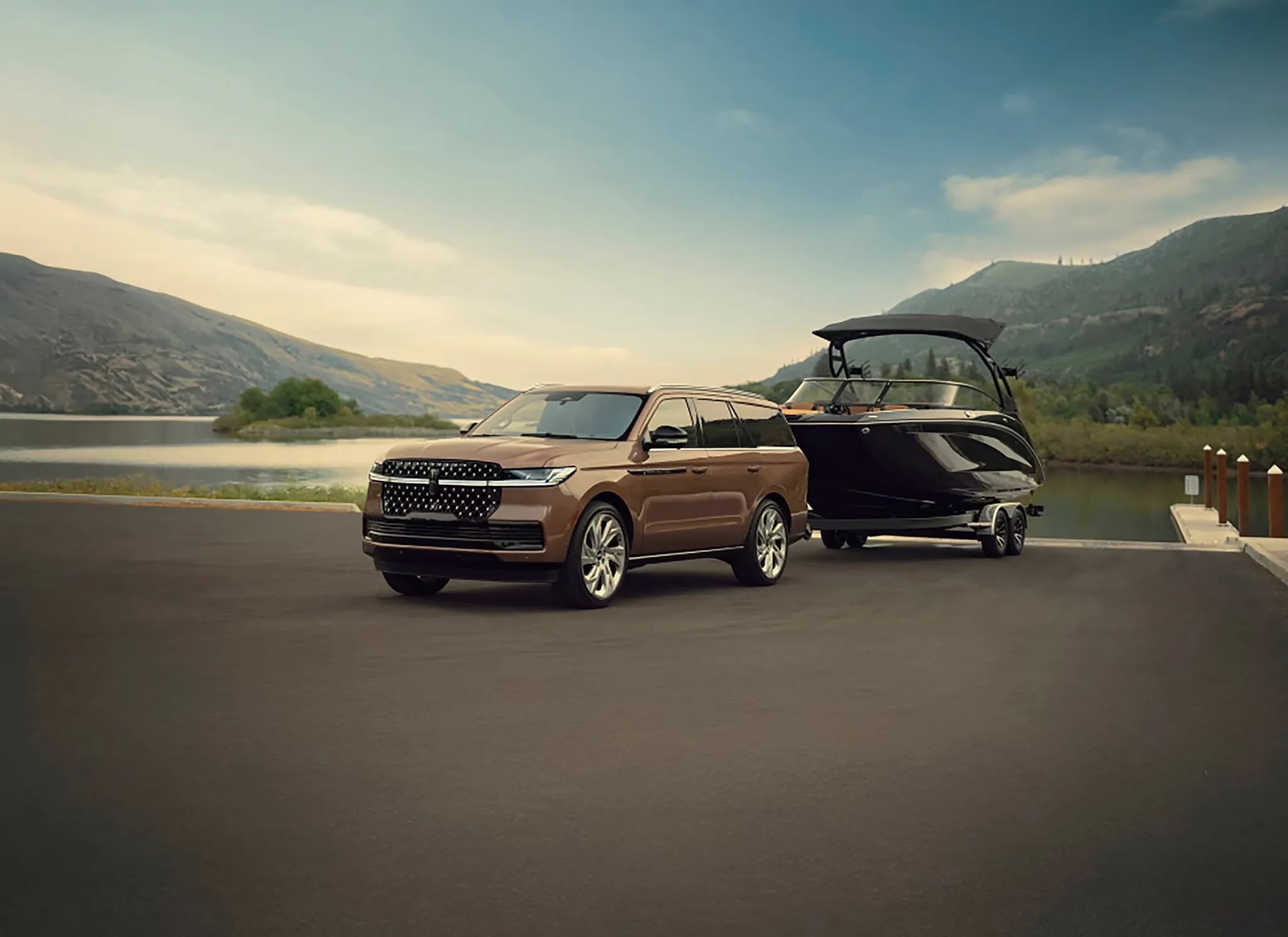 2026 Lincoln Navigator luxury SUV parked beside lake with boat trailer lifestyle scene