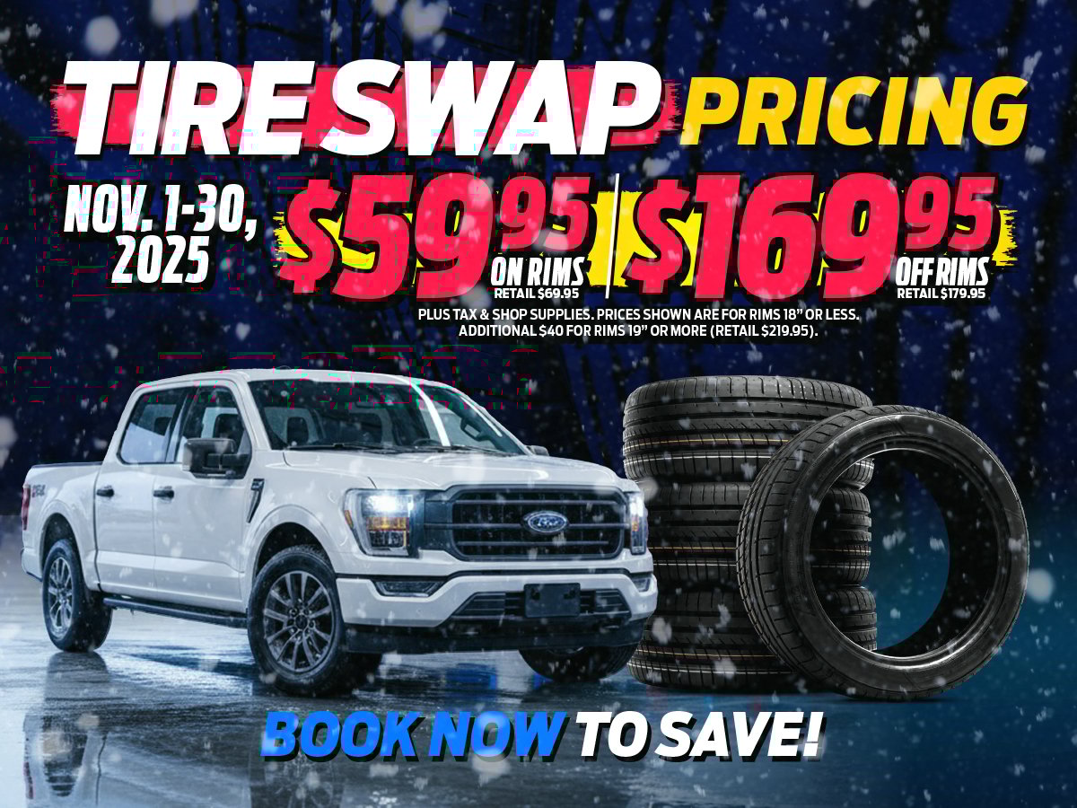 Snowy scene with a white Ford F-150 and stack of winter tires, advertising Freedom Ford’s November tire swap special.