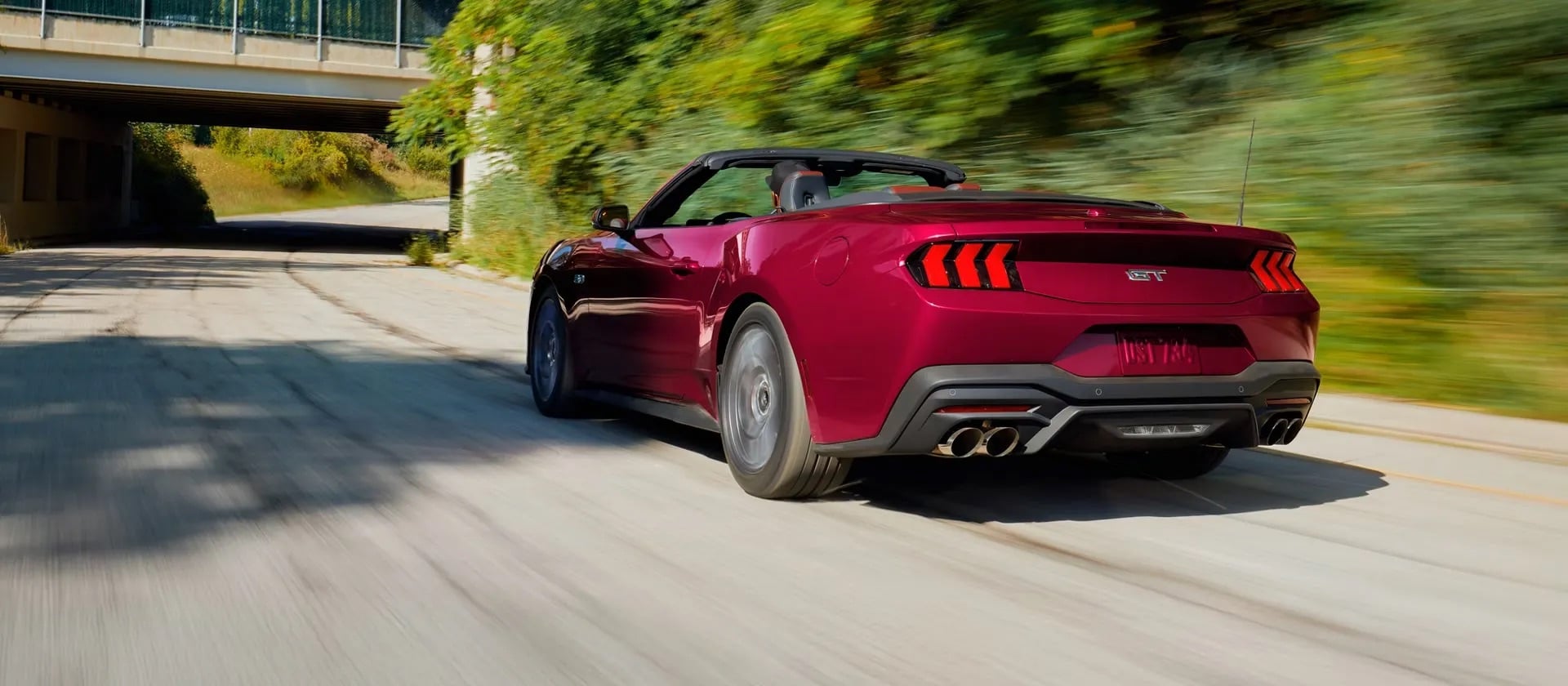 2026 Ford Mustang convertible in Molten Magenta Metallic Tinted Clearcoat, featuring an open-top design, bold exterior lines, and sporty performance-inspired styling