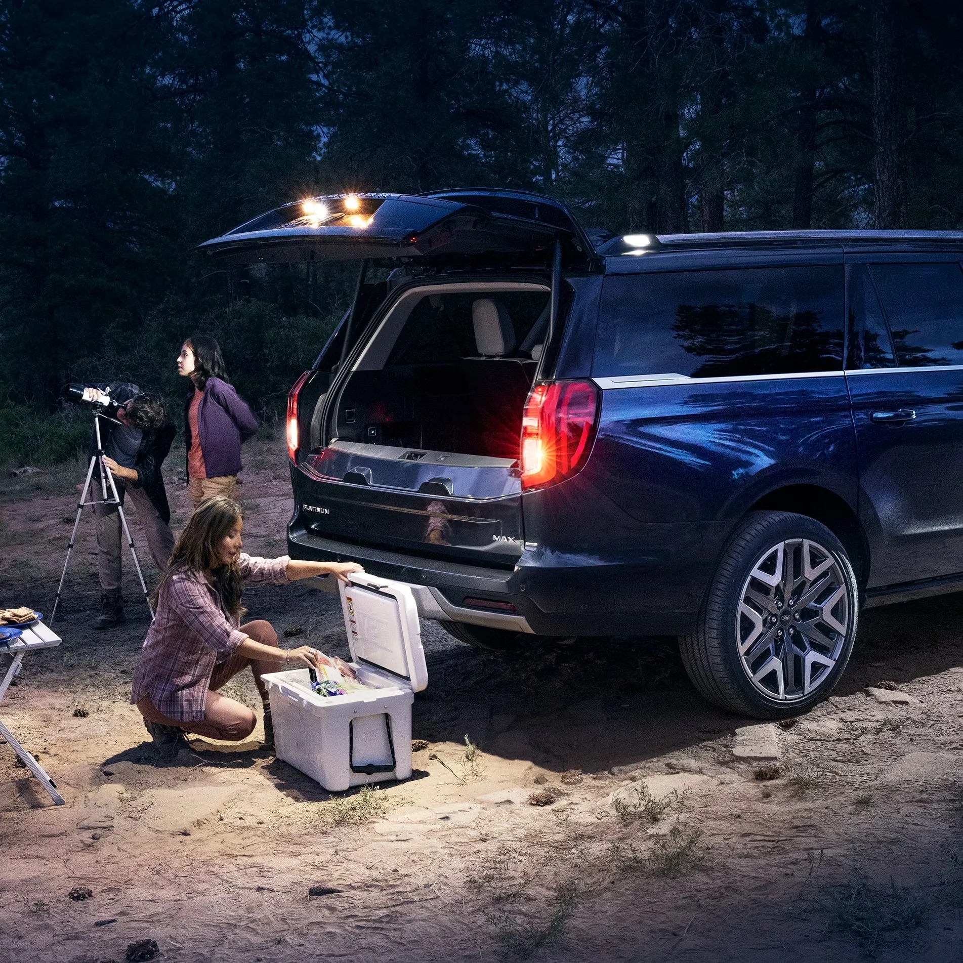 2026 Ford Expedition set up for camping, parked in a scenic outdoor area with gear loaded, demonstrating spacious interior and outdoor versatility.