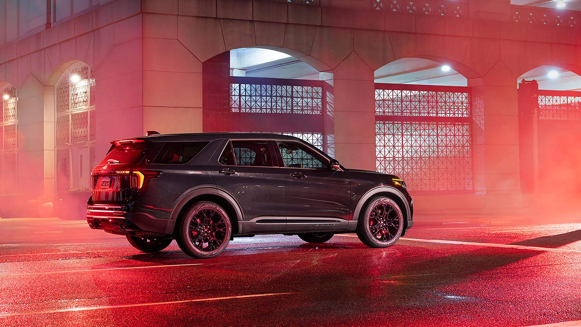 Side profile of a Ford Explorer outside a red-lit industrial building