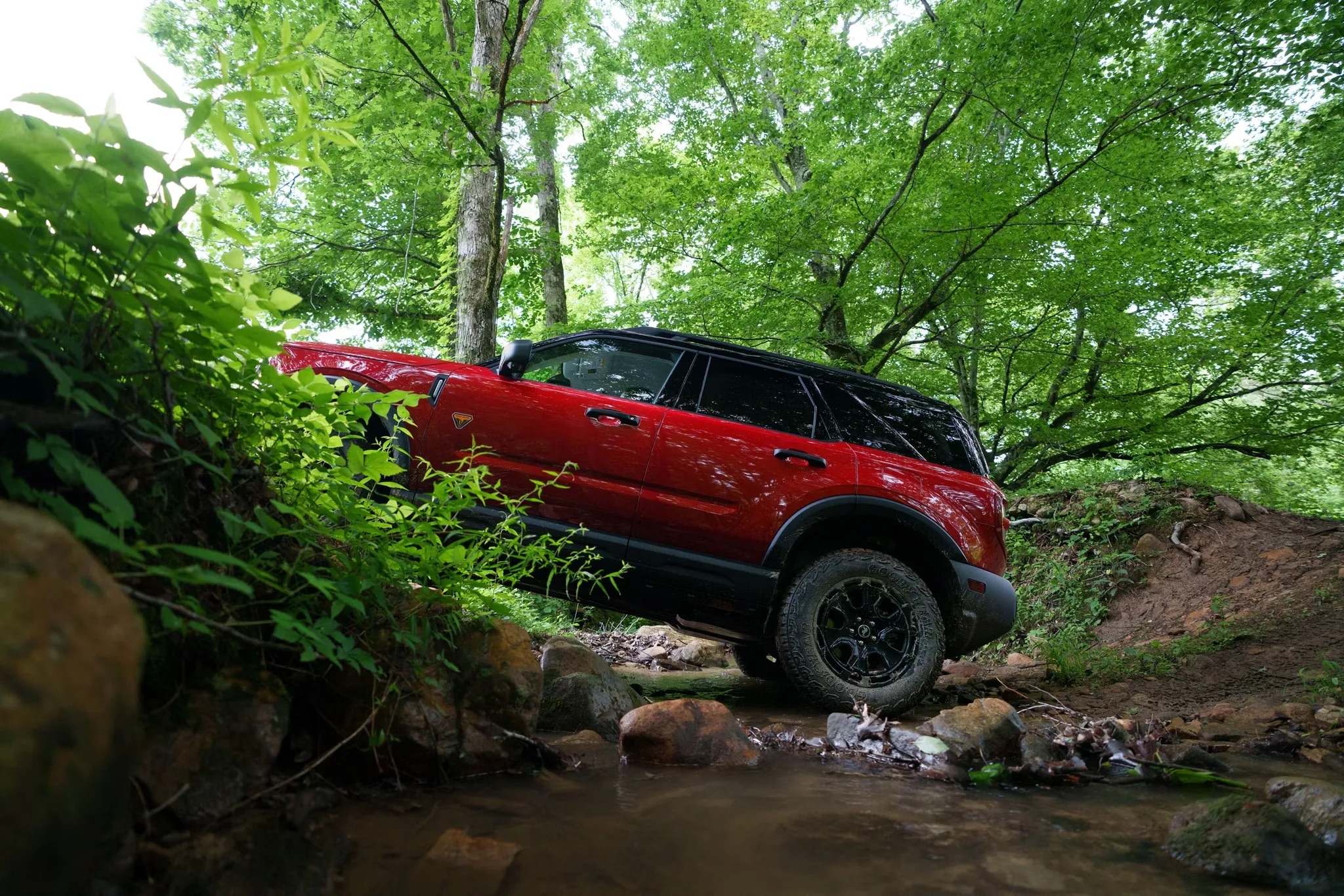 Red 2026 Ford Bronco Sport driving through a forested area
