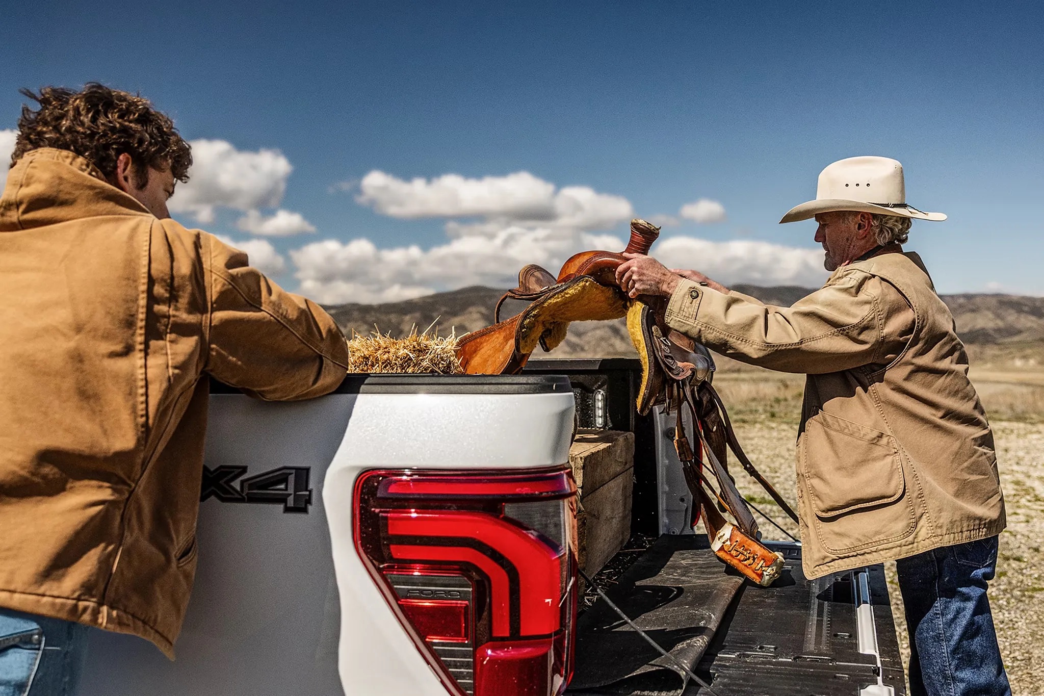 People standing at the tailgate of a 2026 Ford F-150 with outdoor gear