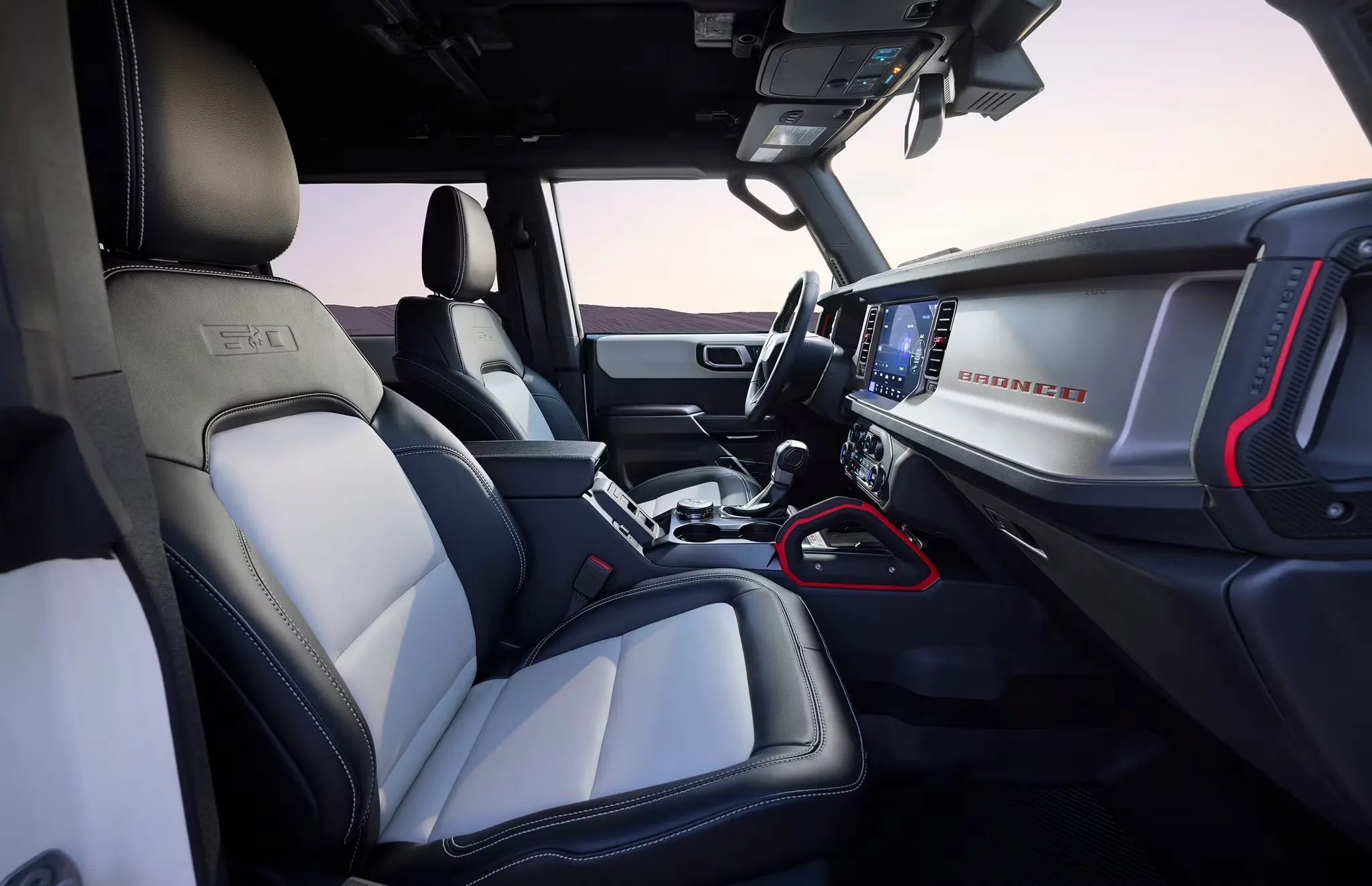 Ford Bronco interior featuring light grey seats and trim, highlighting the spacious cabin, durable materials, and driver-focused layout.