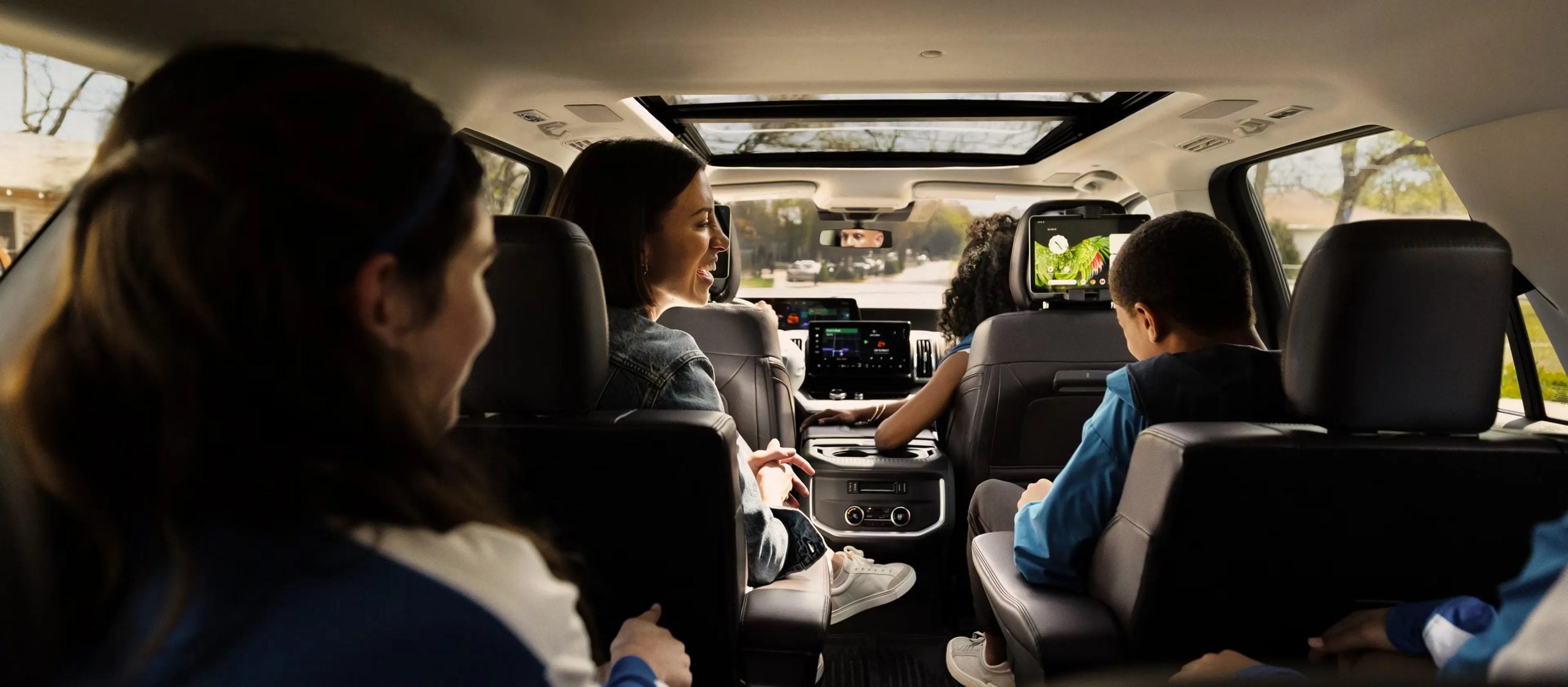 Interior view of passengers seated inside the Ford Expedition during a road trip.