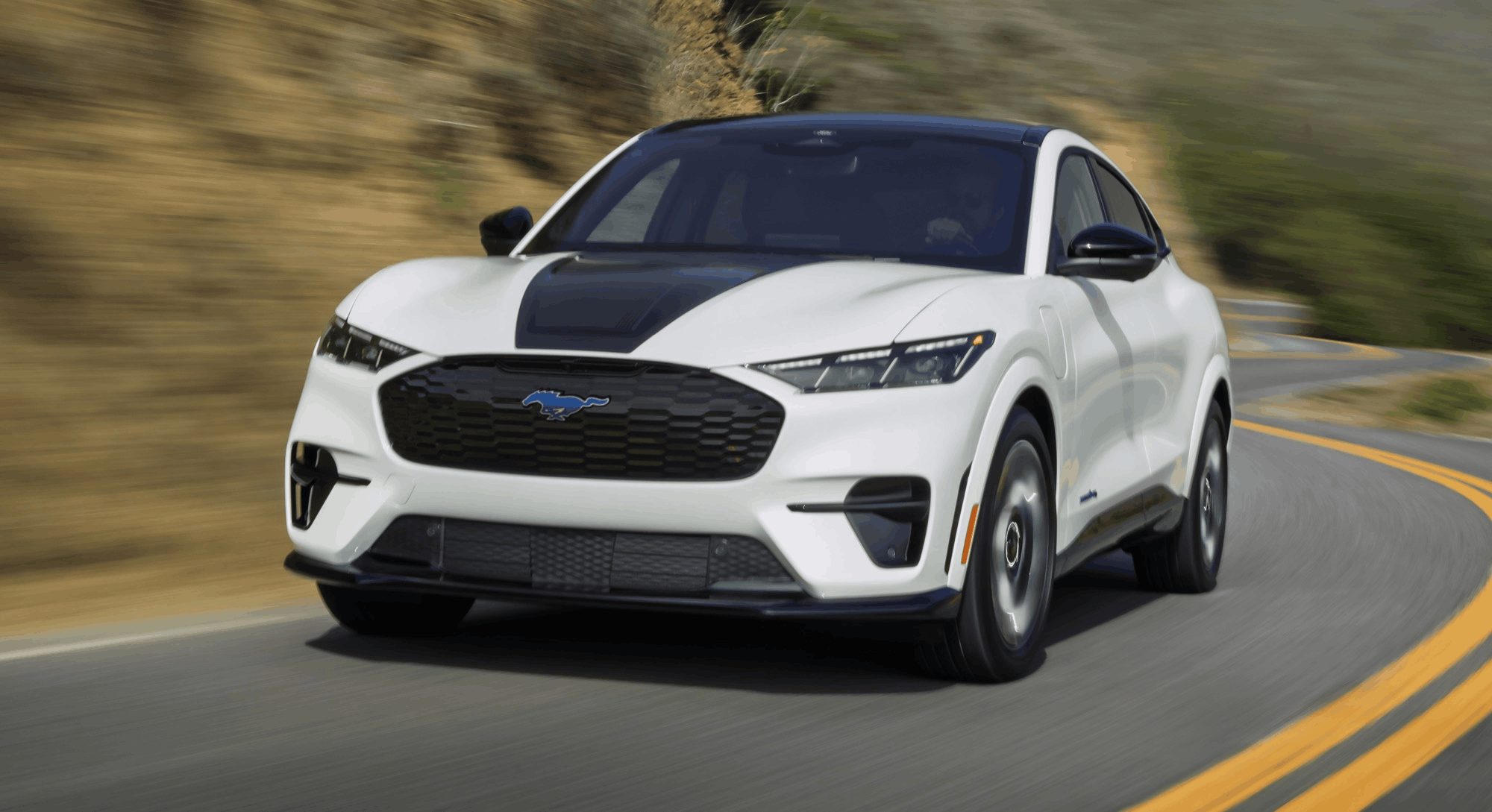 2026 Ford Mustang Mach-E white electric SUV driving on curved road