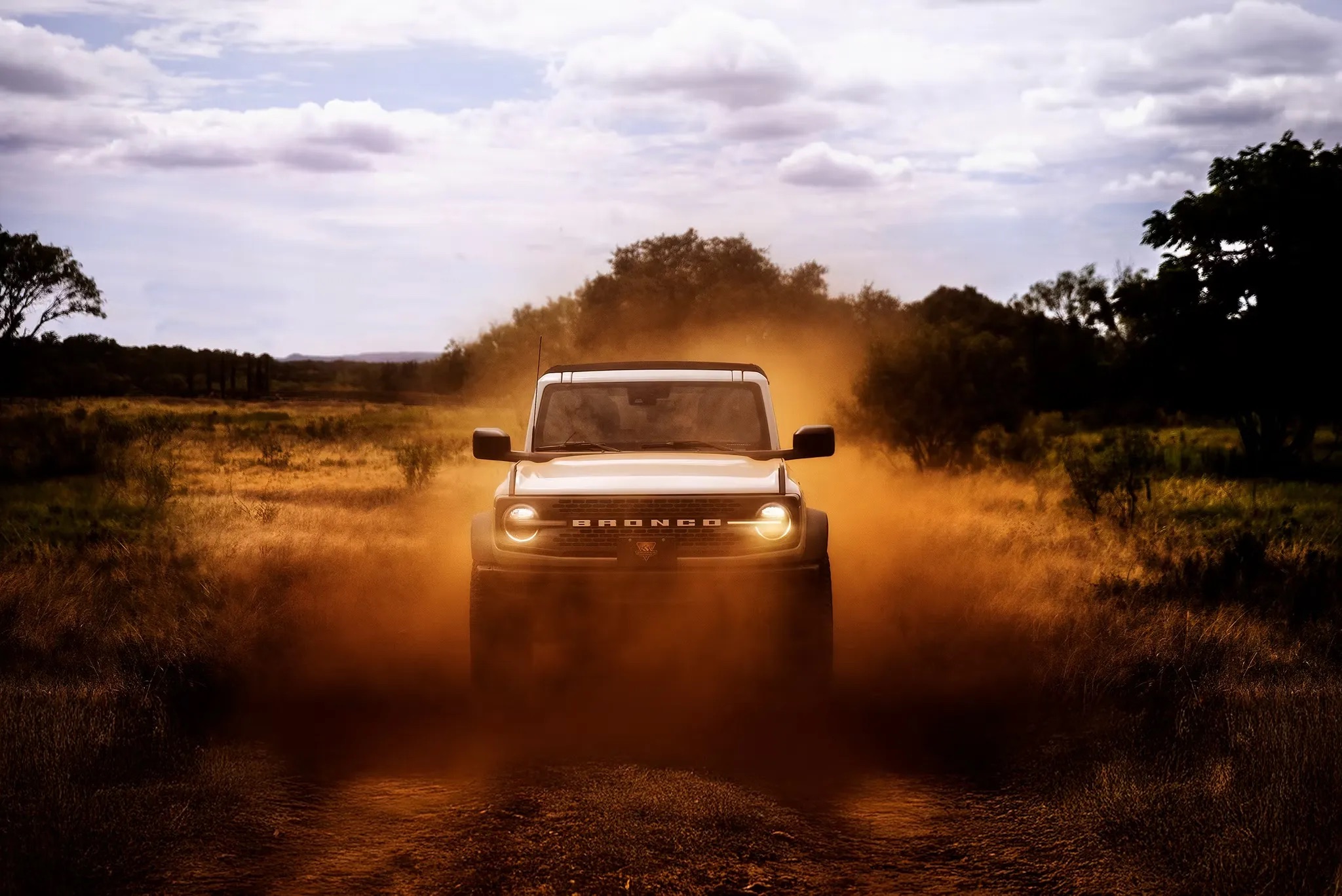 2026 Ford Bronco driving on dirt road kicking up dust