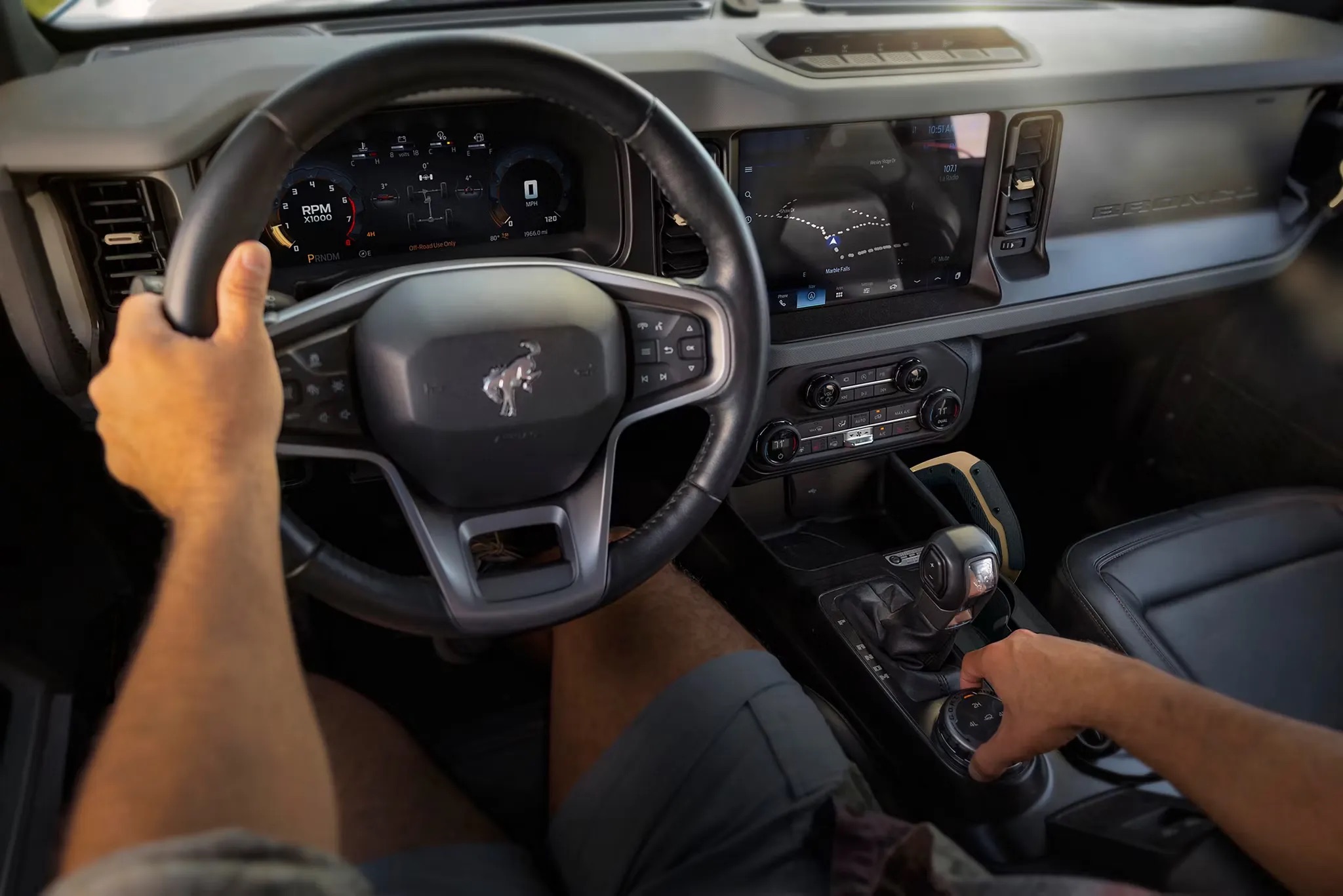 2026 Ford Bronco driver cockpit with steering wheel and dashboard controls