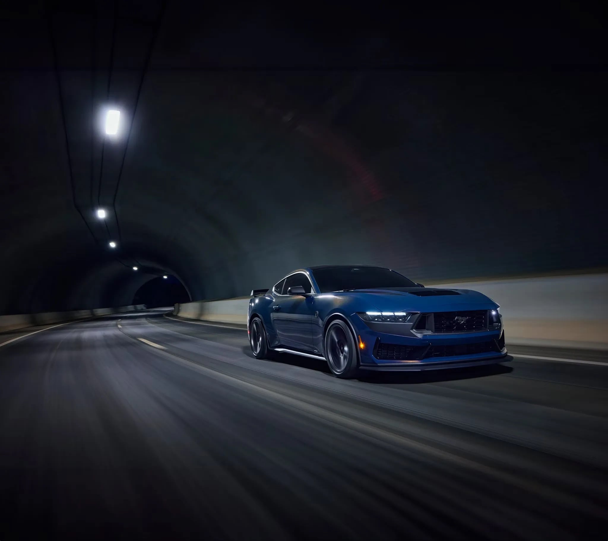 2026 Ford Mustang driving at night with headlights on performance shot