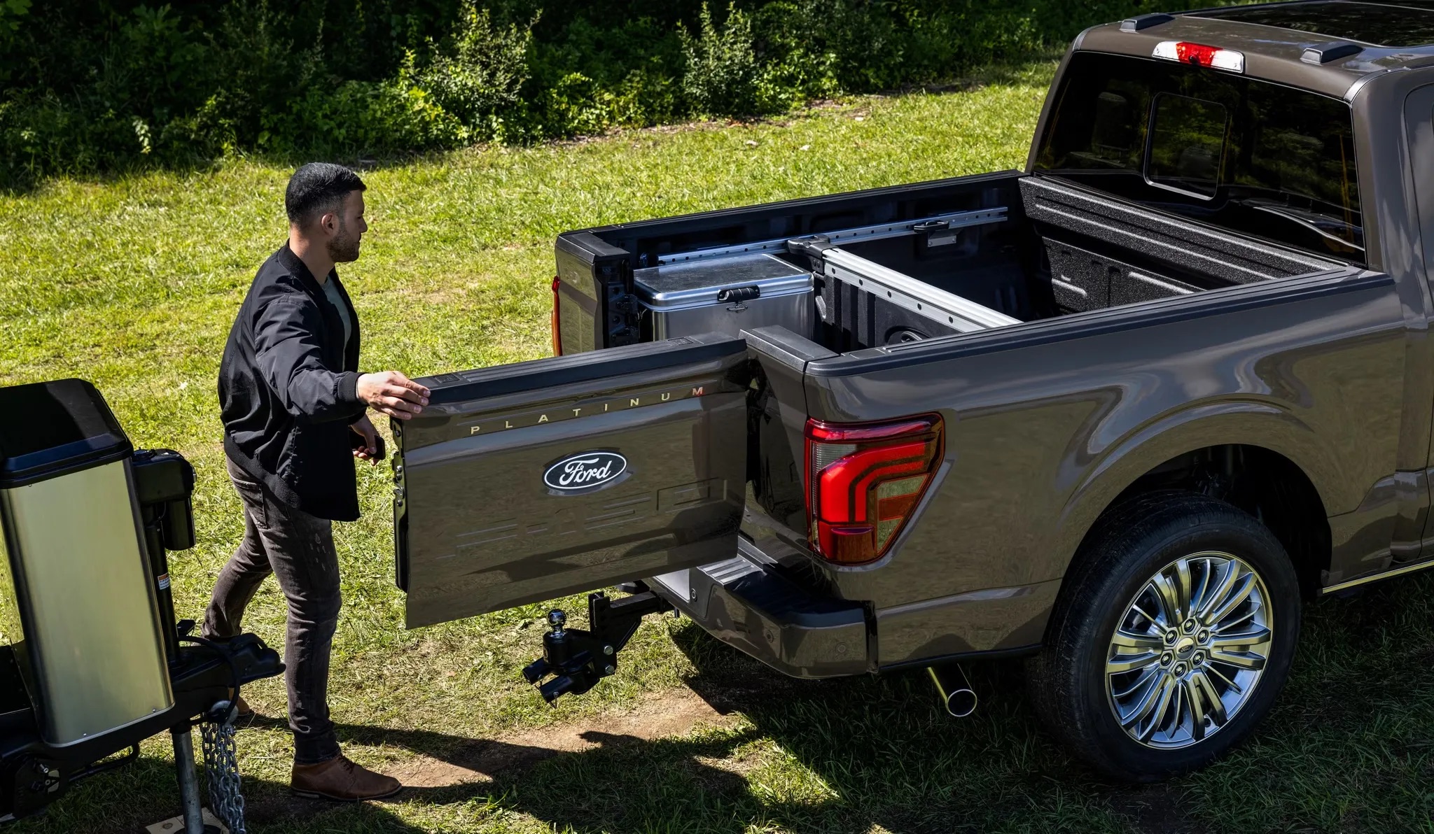 Person standing beside an open truck bed outdoors