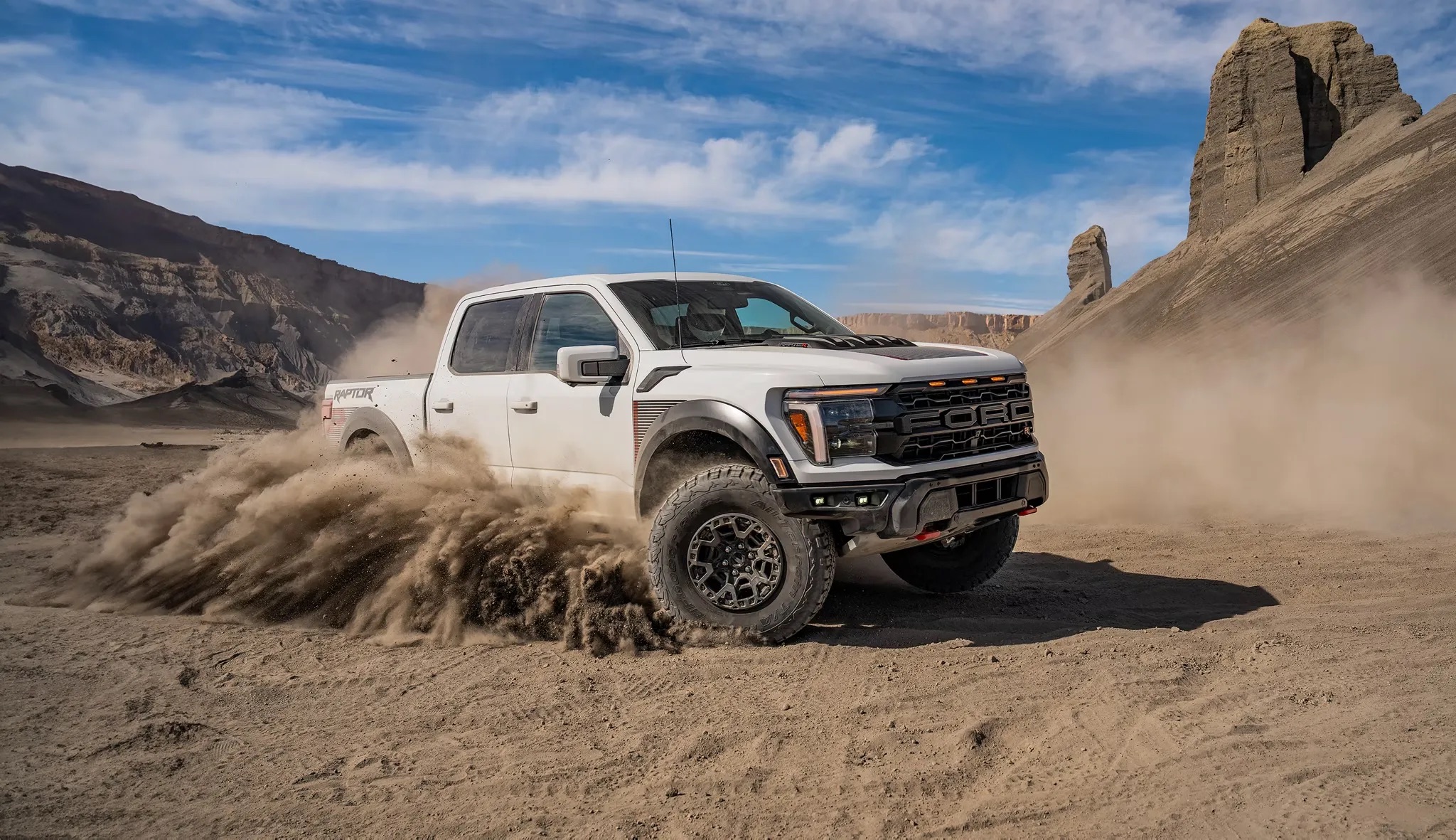 Pickup truck driving through sand dunes