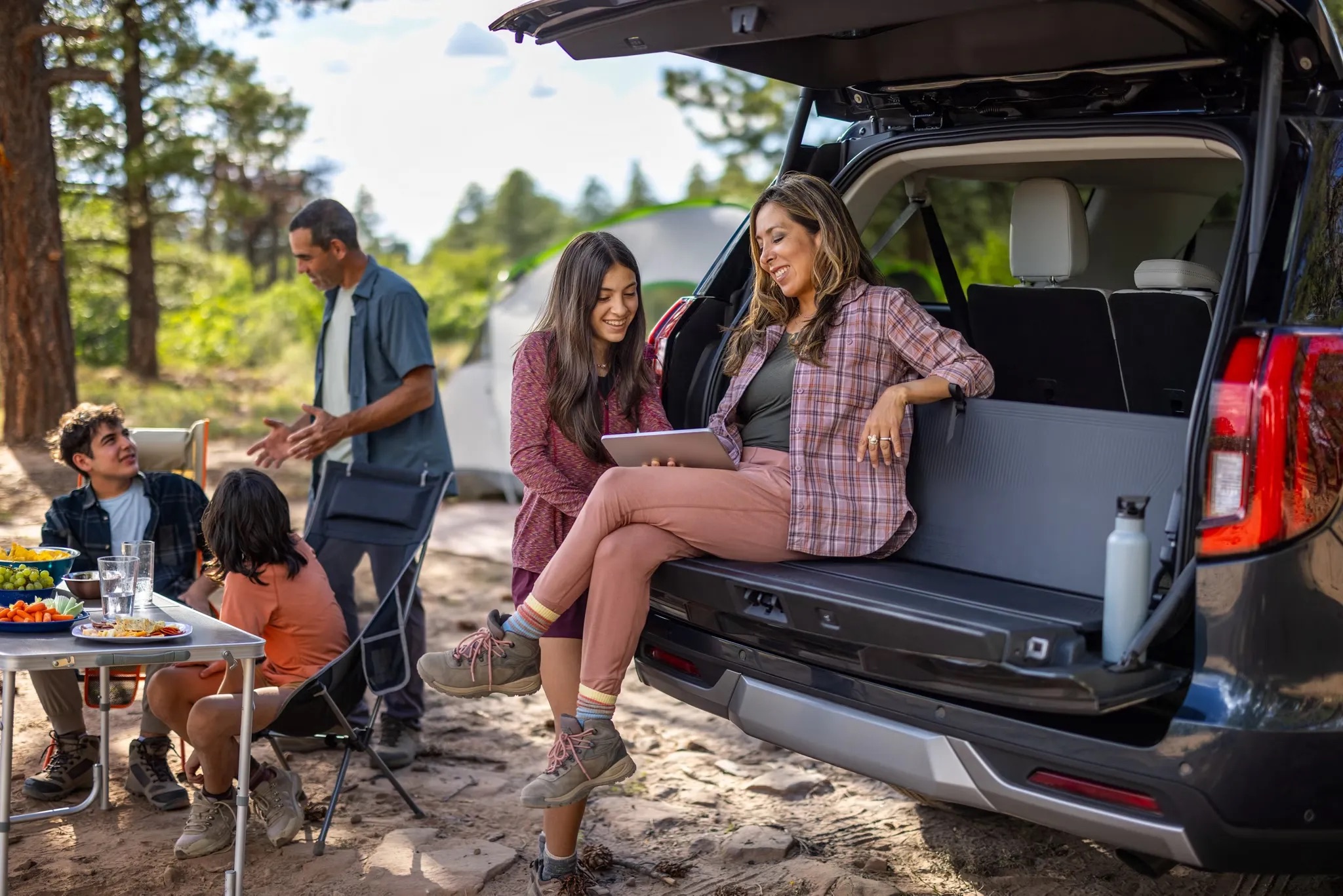 2026 Ford Expedition tailgate open with people sitting in cargo area lifestyle