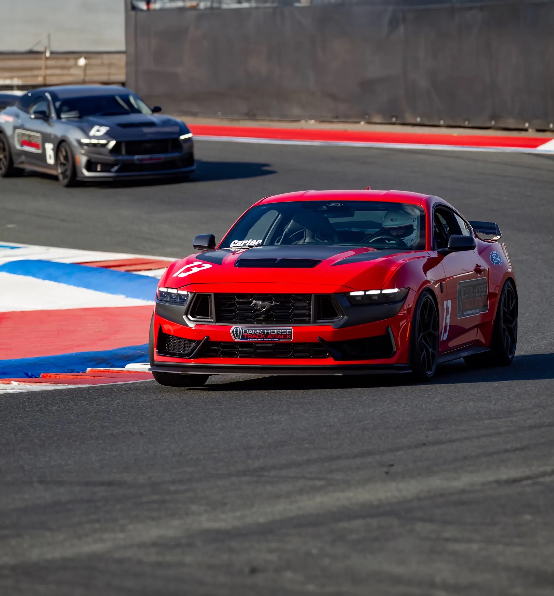 2026 Ford Mustang performance model driving on racetrack front three quarter view
