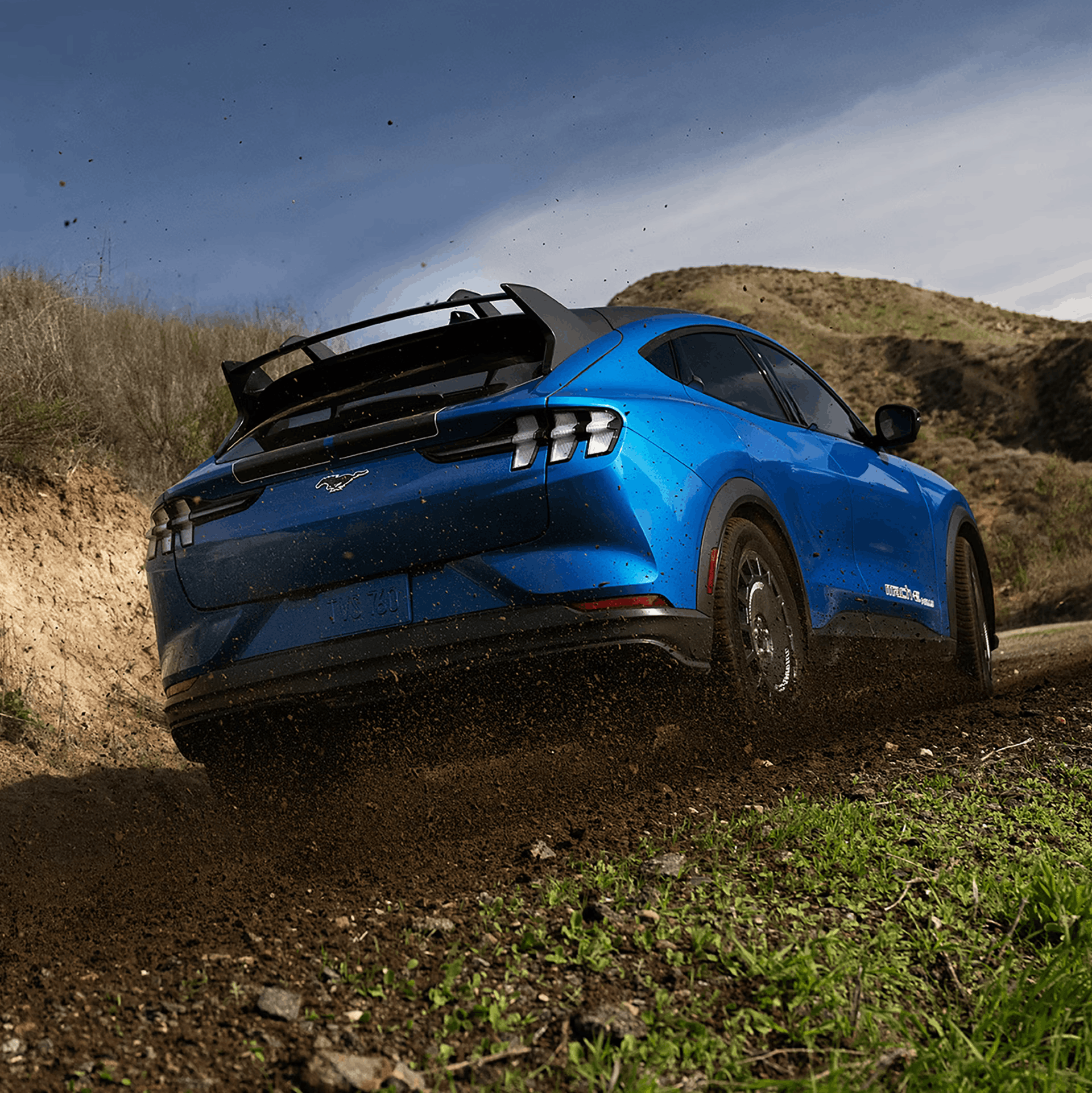 2026 Ford Mustang Mach-E blue SUV driving off road on dirt terrain