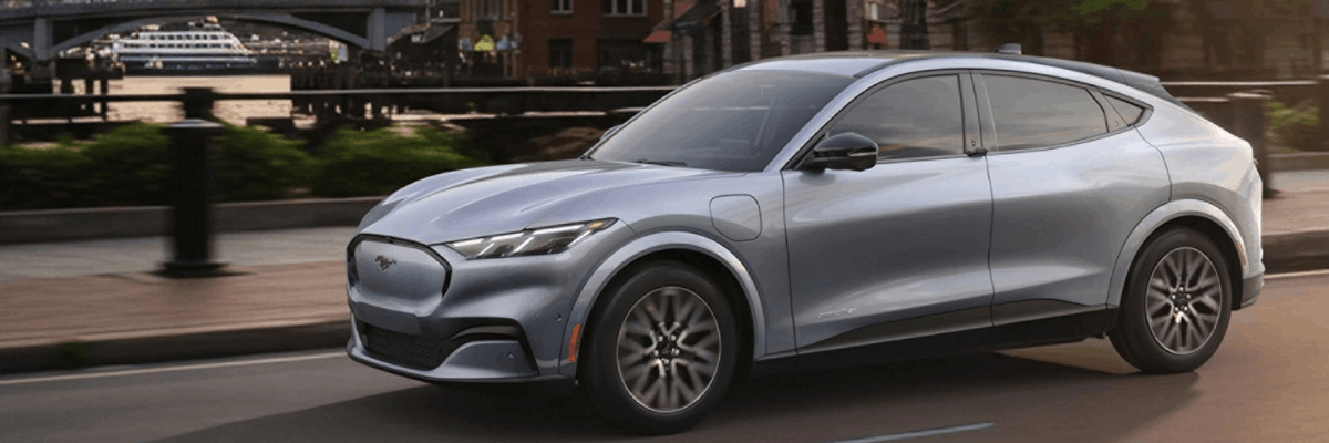 2026 Ford Mustang Mach-E silver electric SUV driving in city environment
