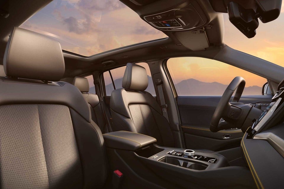 2026 Jeep Cherokee interior highlighting leather seats, yellow stitching, and panoramic sunroof with mountain view.