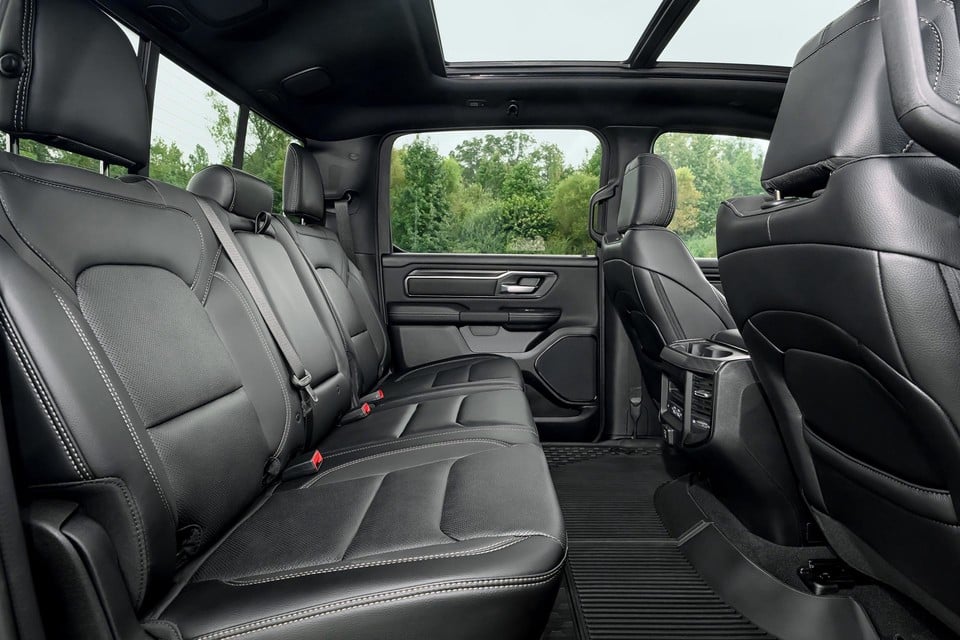 Interior of the 2026 Ram 1500 featuring spacious rear seating with premium black leather upholstery and panoramic sunroof