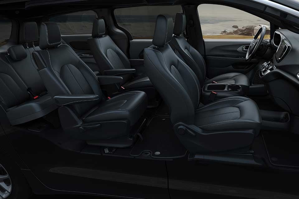 Interior of the 2026 Chrysler Grand Caravan featuring three rows of black leather seating with ample legroom