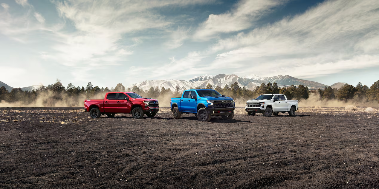 Three 2025 Chevrolet Silverado vehicles parked by the cliffs.