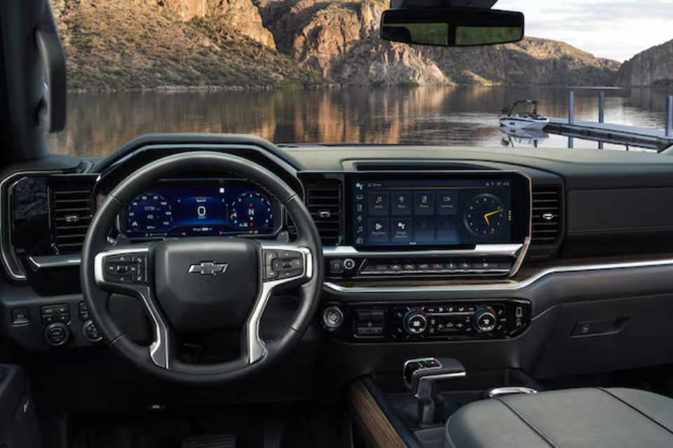 “Interior of the 2026 Chevrolet Silverado 1500 showing a modern digital cockpit with a large touchscreen and lake view through the windshield