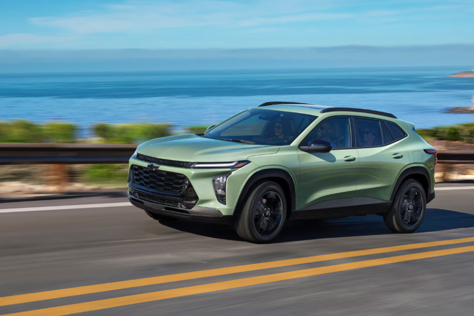 2026 Chevrolet Trax driving along a coastal highway with ocean views, showcasing its modern design and aerodynamic profile