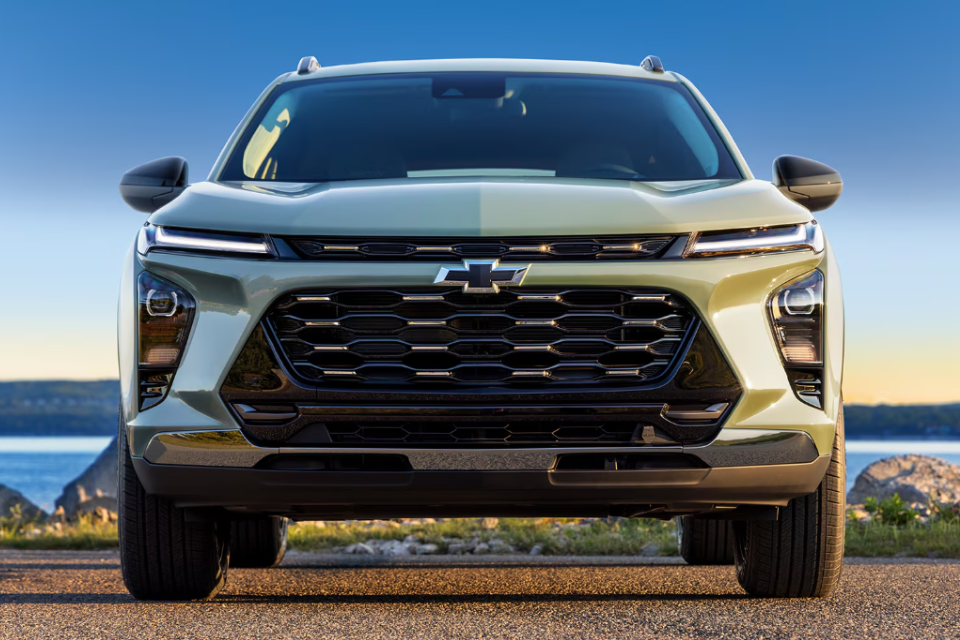 Front view of the 2026 Chevrolet Trax against a lakeside backdrop, highlighting its signature LED lighting and sporty grille