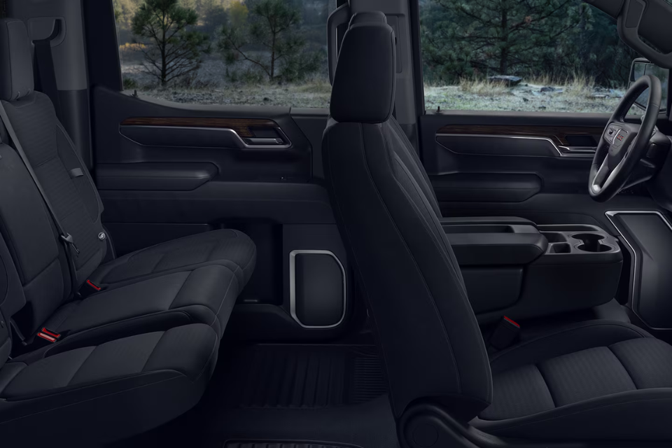Spacious 2026 GMC Sierra 1500 interior cabin with black leather seats and refined wood accents