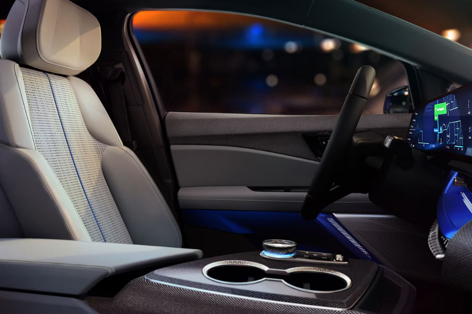 Interior view of the 2026 Cadillac Optiq featuring refined seating and ambient lighting with a modern digital display