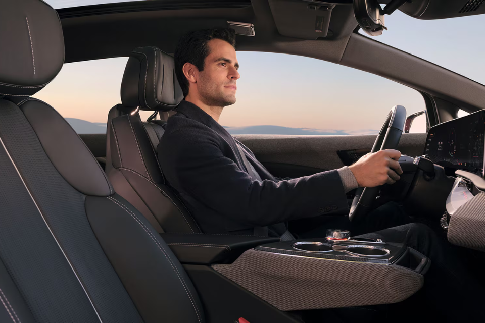 Driver inside the 2026 Cadillac Optiq enjoying a luxurious interior with premium materials and a panoramic dashboard display