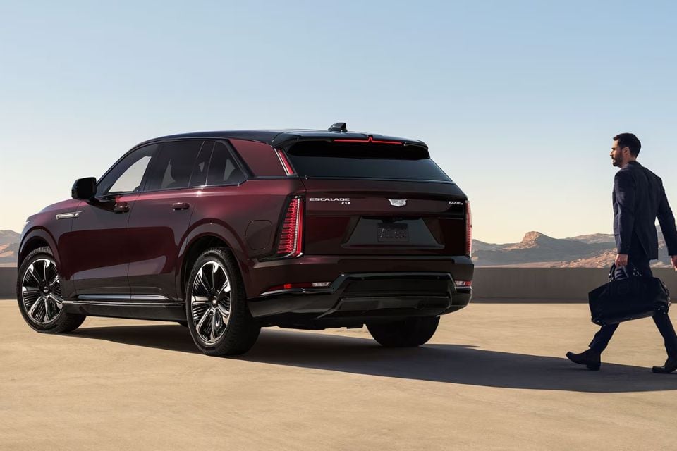 Rear three-quarter view of the 2026 Cadillac Escalade IQ with vertical LED taillights and modern styling