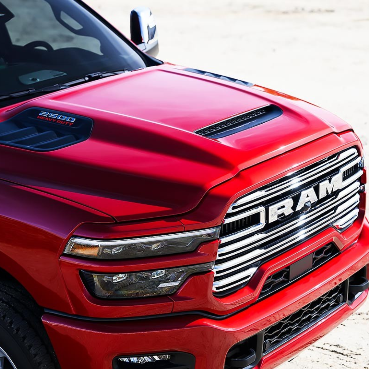 Close-up of red 2025 Ram 2500 HD hood and chrome grille with 2500 Heavy Duty badging