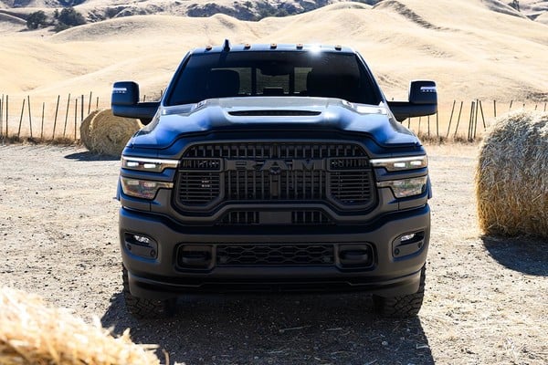 Front view of a black 2025 Ram 2500 HD Power Wagon parked in a rural setting with hay bales