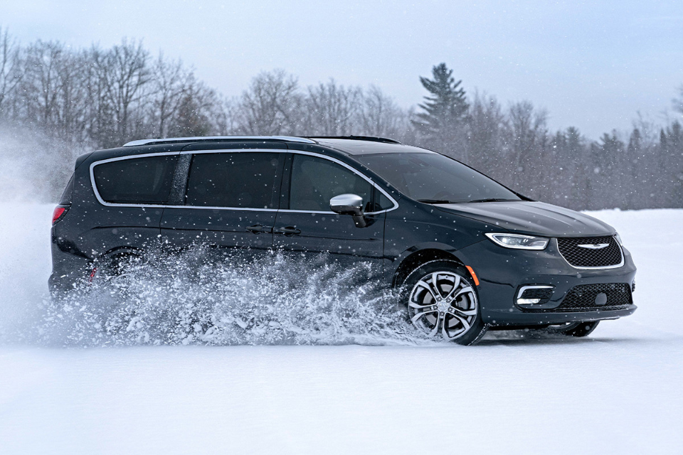 2026 Chrysler Pacifica driving through snowy terrain, demonstrating all-wheel drive performance and confident winter capability