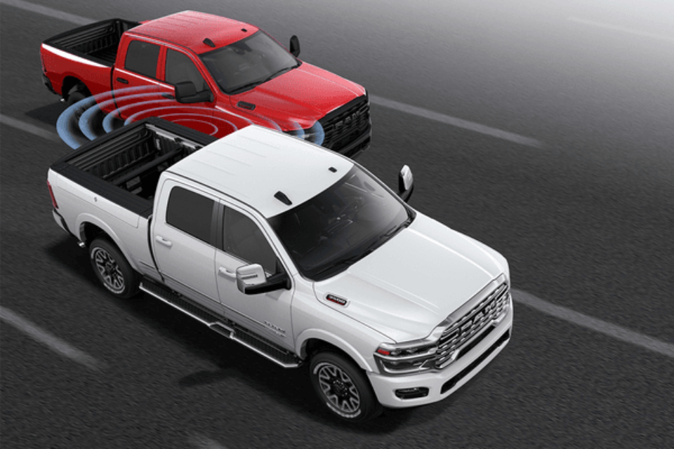 2026 Ram 2500 models demonstrating Blind-Spot Monitoring technology with safety sensors active on the highway