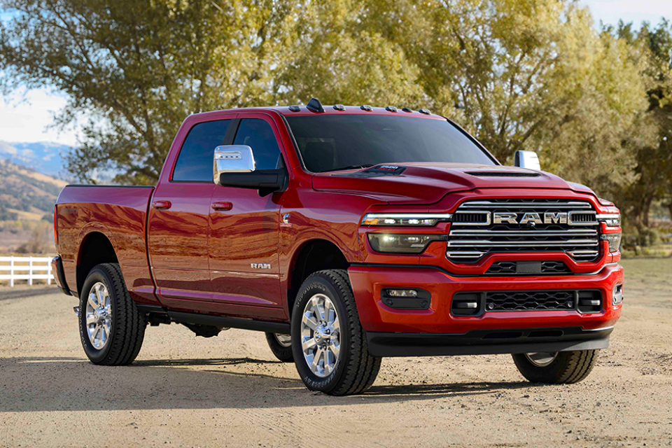 2026 Ram 2500 Limited in red parked outdoors, highlighting its chrome grille and premium craftsmanship