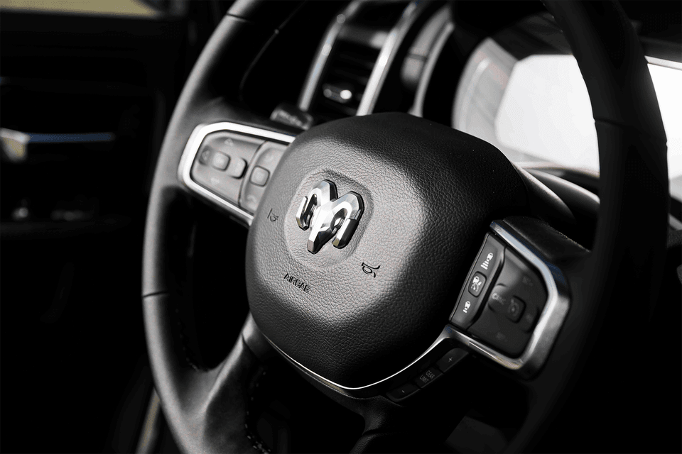 Close-up of the 2026 Ram 2500 steering wheel featuring the bold Ram logo and modern control buttons.