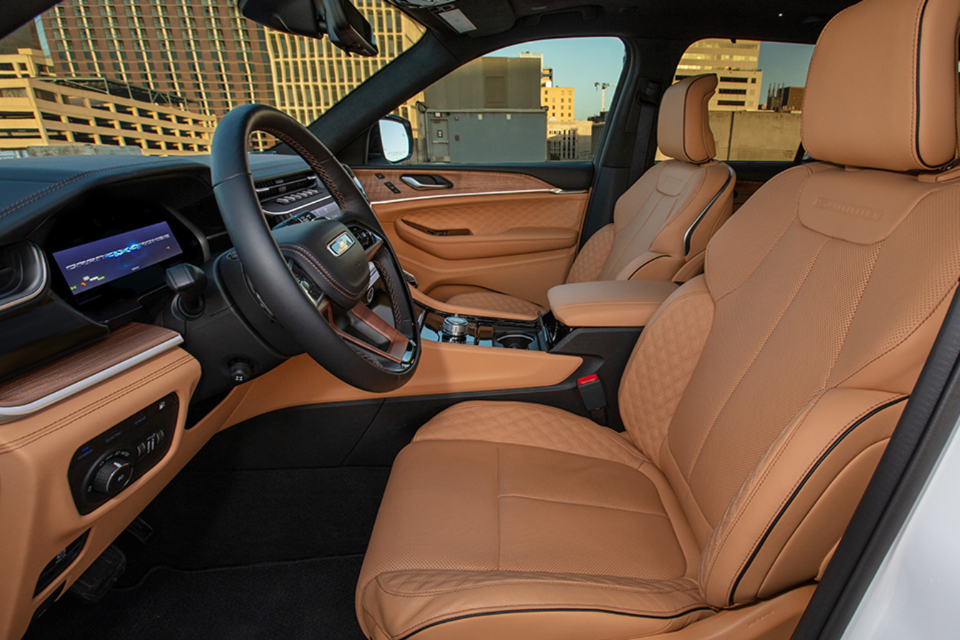 Front cabin of a 2026 Jeep Grand Cherokee with tan quilted leather seats and wood-look trim