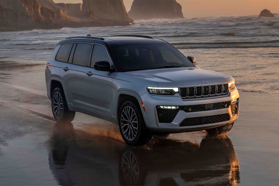 2026 Jeep Grand Cherokee on wet sand near the ocean during golden hour