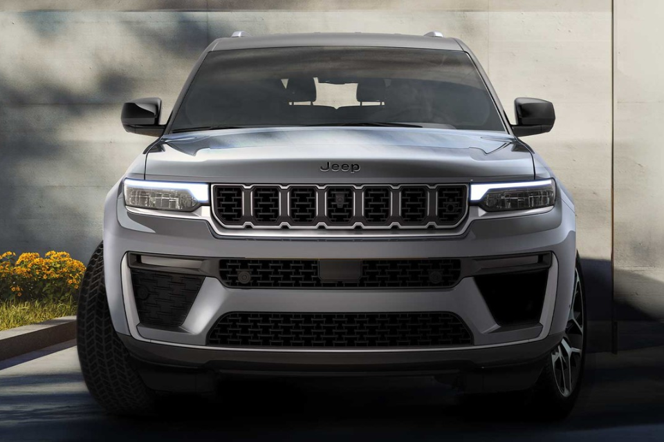 Head-on view of a 2026 Jeep Grand Cherokee emphasizing the seven-slot grille and LED lighting